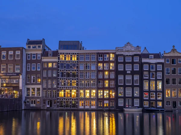 Geleneksel kanal üzerinde Damrak gece karanlığında Amsterdam'da ev sahipliği yapmaktadır. Kanaldaki binalar şimdi çok popüler olan geleneksel Hollanda mimari biçimidir.