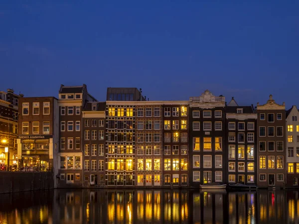 Geleneksel kanal üzerinde Damrak gece karanlığında Amsterdam'da ev sahipliği yapmaktadır. Kanaldaki binalar şimdi çok popüler olan geleneksel Hollanda mimari biçimidir.