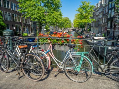 Amsterdam, Hollanda - 22 Temmuz 2018: Eski bisiklet boyunca Amsterdam'da bir kanal üzerinde bir köprü. Popüler bir mod ulaşım burada olduğu gibi çok sayıda kanal kilitli bisiklet vardır.