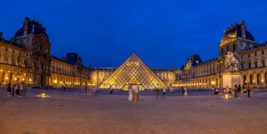 Paris, Fransa - 28 Temmuz 2018: Dışarıda Louvre Müzesi Paris, Fransa akşamları. Turistler ve insanlar piramit girişinde olduğu avluda görülebilir.