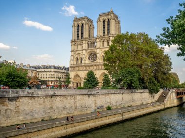 Paris, Fransa - 1 Ağustos 2018: Paris'te Seine Nehri boyunca ünlü Notre Dame Katedrali görünümü. İnsanlar nehir dolgu görebildiği.