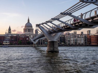 Gece karanlığında Thames Nehri kapsayan Millennium Köprüsü. St Paul Katedrali karşı kıyıda yer alır.
