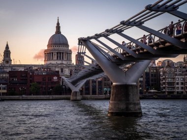 Gece karanlığında Thames Nehri kapsayan Millennium Köprüsü. St Paul Katedrali karşı kıyıda yer alır.