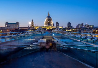 Gece karanlığında Thames Nehri kapsayan Millennium Köprüsü. St Paul Katedrali karşı kıyıda yer alır.