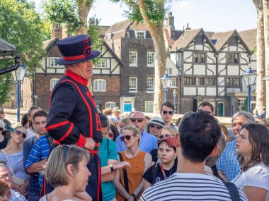 Londra, İngiltere - 5 Ağustos 2018: A Yeomen Warder içinde Londra Kulesi bir gruba bir konuşma sıcak yaz gününde. Bu tarihi Norman kale İngiltere nin en ünlü turistik 's.