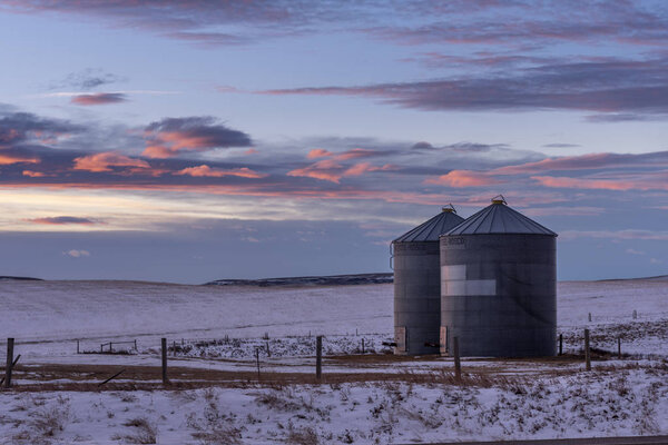 Old grain bins on the Canadian prairie at sunset. 