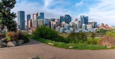 Calgary'nin silueti bir bahar sabahı. Calgary Maratonu'na katılan koşucular Memorial Drive'da ön planda.