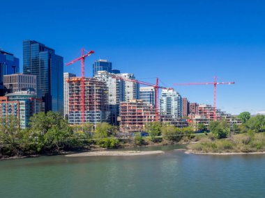 Calgary, Alberta bir proje sitesinde inşaat vinçler. Apartmalar Bow Nehri boyunca inşaat altında.