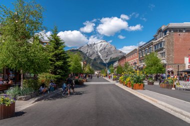 Banff, Alberta - 21 Haziran 2020: Banff Bulvarı boyunca Banff kasabasında güzel bir günde. Banff Bulvarı, Coronavirus salgınından sonra açılan araç trafiği nedeniyle kapatıldı..