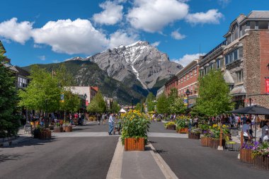 Banff, Alberta - 21 Haziran 2020: Banff Bulvarı boyunca Banff kasabasında güzel bir günde. Banff Bulvarı, Coronavirus salgınından sonra açılan araç trafiği nedeniyle kapatıldı..