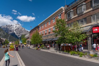 Banff, Alberta - 21 Haziran 2020: Banff Bulvarı boyunca Banff kasabasında güzel bir günde. Banff Bulvarı, Coronavirus salgınından sonra açılan araç trafiği nedeniyle kapatıldı..