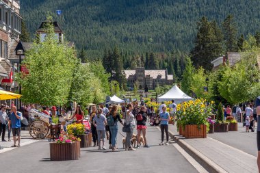 Banff, Alberta - 21 Haziran 2020: Banff Bulvarı boyunca Banff kasabasında güzel bir günde. Banff Bulvarı, Coronavirus salgınından sonra açılan araç trafiği nedeniyle kapatıldı..