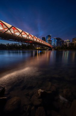 Gün doğumunda Calgary Alberta 'daki Bow Nehri üzerindeki yaya köprüsünün görüntüsü..