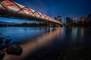 Gün doğumunda Calgary Alberta 'daki Bow Nehri üzerindeki yaya köprüsünün görüntüsü..