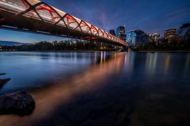 Gün doğumunda Calgary Alberta 'daki Bow Nehri üzerindeki yaya köprüsünün görüntüsü..
