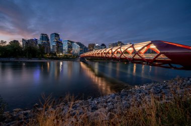 Gün doğumunda Calgary Alberta 'daki Bow Nehri üzerindeki yaya köprüsünün görüntüsü..