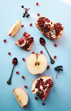 Mavi arka plan üzerinde olgun elma ve nar vintage kaşık ile üstten görünüm