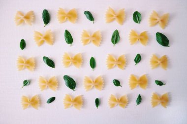 farfalle makarna fesleğen ile beyaz yüzey üzerinde bırakır