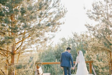 Düğün gününde yeni evliler şık birkaç. Mutlu genç gelin, zarif damat tutuşup walking away