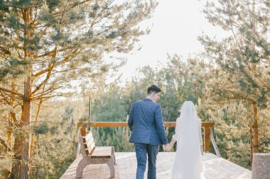 Düğün gününde yeni evliler şık birkaç. Mutlu genç gelin, zarif damat tutuşup walking away