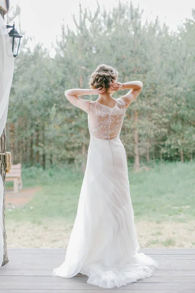 Genç mutlu gelin ona düğün gününde, bir gelinlik arkası ayrıntılarını