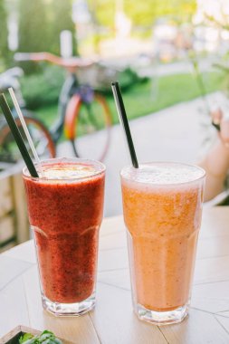 Sağlıklı beslenme ve yaz konsepti. Smoothies ve Cafe yaz Teras, ahşap masa snacks iki bardak.