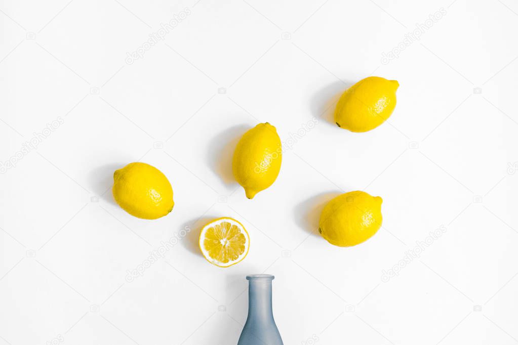 Water bottle and a half of lemon on white background. Flat lay, top view