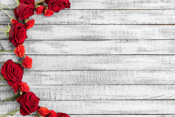 Top view of red roses on grungy grey wooden table with copy space