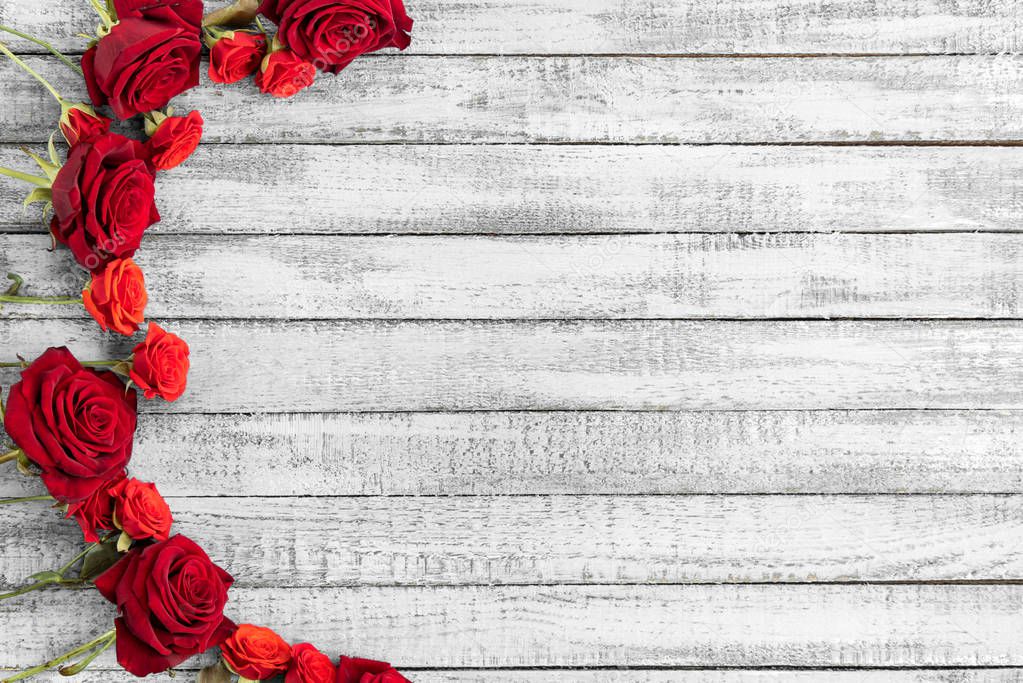 Top view of red roses on grungy grey wooden table with copy space