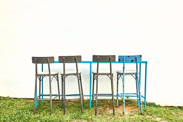 Blue and gray bar stools near the white wall