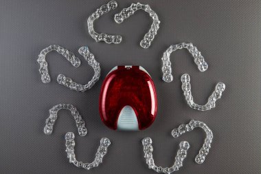 Gri arka plan, yeni ortodontik ekipmanlar üzerinde görünmez parantezveya görünmez tutucuların üst görünümü