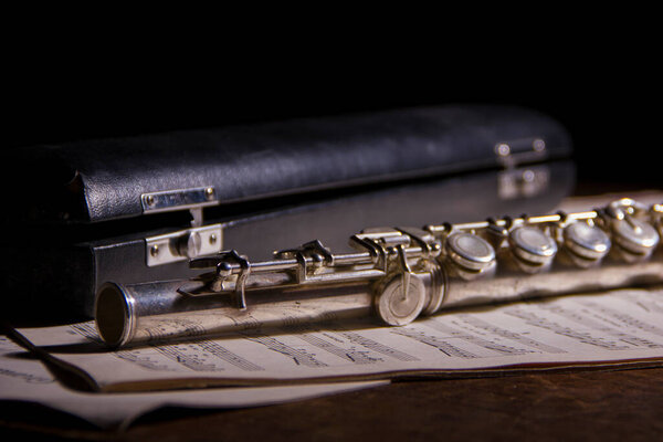 Серебряная флейта на древнем музыкальном фоне
.