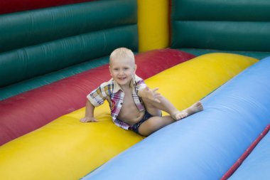 neşeli çocuk şişme bir trambolin üzerinde oturur