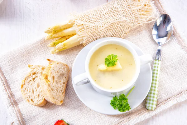 Asparagus cream soup with capers and fresh baguette — Stock Image Asparagus Cream Soup Capers Fresh Baguette Royalty Free Stock Images