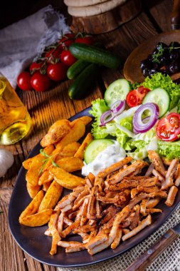 Rustik gyros plaka yeşil salata ve patates dilimleri