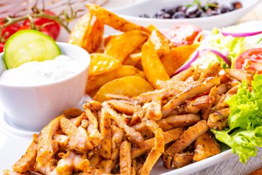 Rustik gyros plaka yeşil salata ve patates dilimleri ile