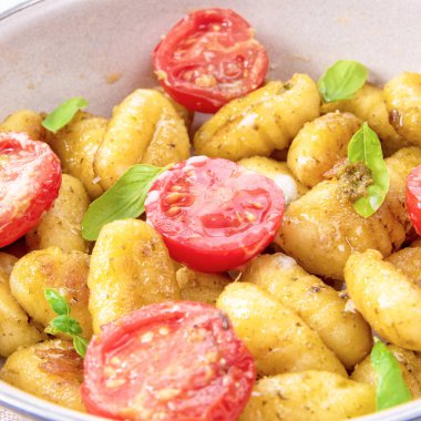 Gnocchi görünümü Kapat pişmiş yeşil pesto, kiraz domates ve parmesan ile