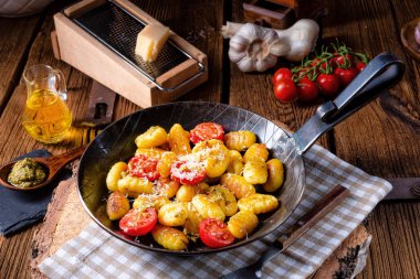 Gnocchi pişmiş yeşil pesto, kiraz domates ve parmesan ile