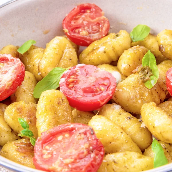 Gnocchi görünümü Kapat pişmiş yeşil pesto, kiraz domates ve parmesan ile