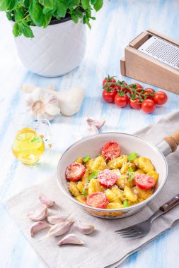 Gnocchi pişmiş yeşil pesto, kiraz domates ve parmesan ile