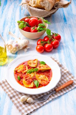 plaka üzerinde Fesleğenli domates soslu ravioli