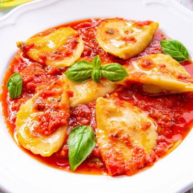 plaka üzerinde Fesleğenli domates soslu ravioli
