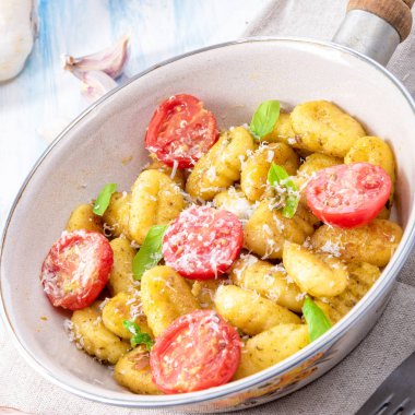 Gnocchi pişmiş yeşil pesto, kiraz domates ve parmesan ile