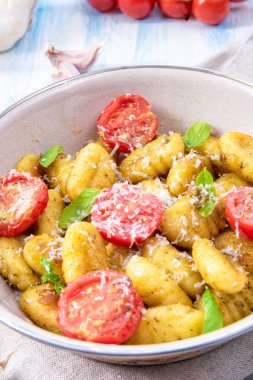Gnocchi pişmiş yeşil pesto, kiraz domates ve parmesan ile