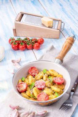 Gnocchi pişmiş yeşil pesto, kiraz domates ve parmesan ile