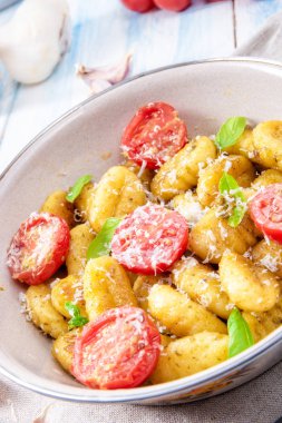 Gnocchi pişmiş yeşil pesto, kiraz domates ve parmesan ile