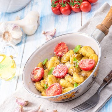 Gnocchi pişmiş yeşil pesto, kiraz domates ve parmesan ile