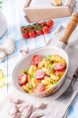 Gnocchi pişmiş yeşil pesto, kiraz domates ve parmesan ile