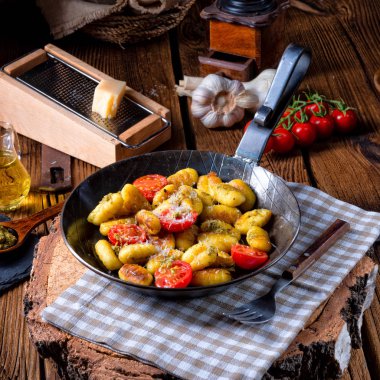 Gnocchi pişmiş yeşil pesto, kiraz domates ve parmesan ile