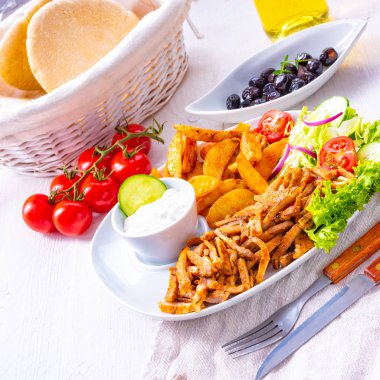 gyros plaka yeşil salata, zeytin ve patates dilimleri